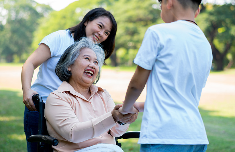 Elderly grandmother in wheelchair beside grandson